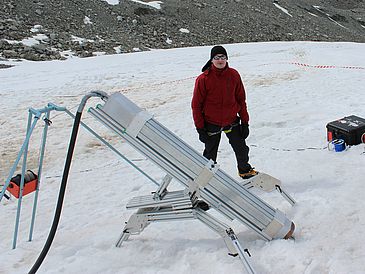 Man in the Antarctica behind a life-size melting probe