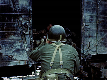 Soldat mit Waffe schaut in einen Waggon