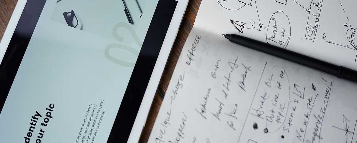 tablet, notebook and pen on a table