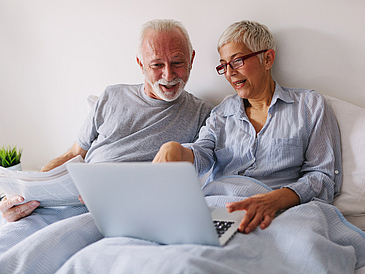 Senioren mit PC im Bett