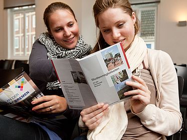 Zwei Frauen schauen sich Hefte an.
