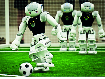 Drei Roboter spielen Fußball