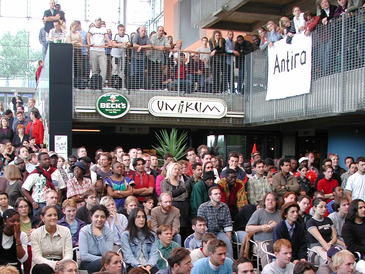 Eine große Menschenmenge lauscht sitzend und stehend in der Glashalle der Uni Bremen einem Redebeitrag.