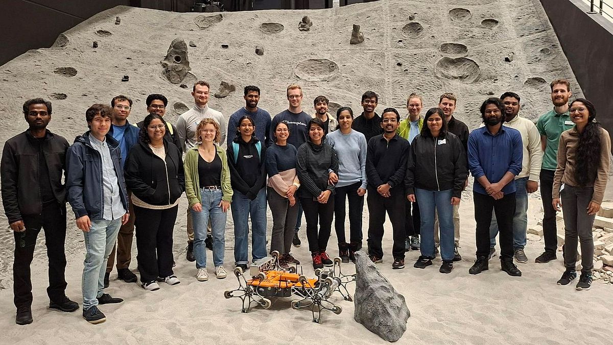 Teilnehmende vor der Rover-Kletteranlage in einer simulierten Mondumgebung.