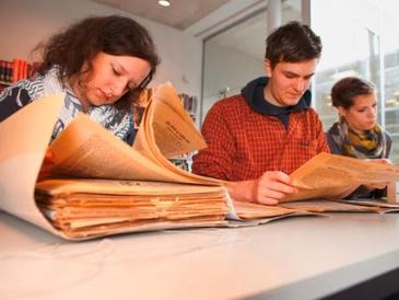 Geschichtsstudierende recherchieren in historischen Akten als Vorbereitung der szenischen Lesung