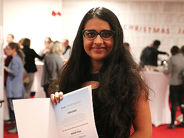 Portrait einer jungen Frau mit Urkunde.