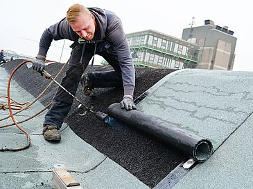 Mann arbeitet auf Dach