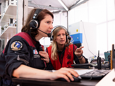 Two female scientists work in front of a computer