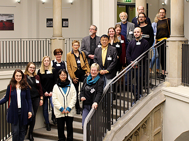Gruppe von Personen steht auf einer großen Treppe