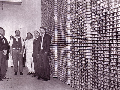 A group of people standing in front of an enormous stack of drill cores.