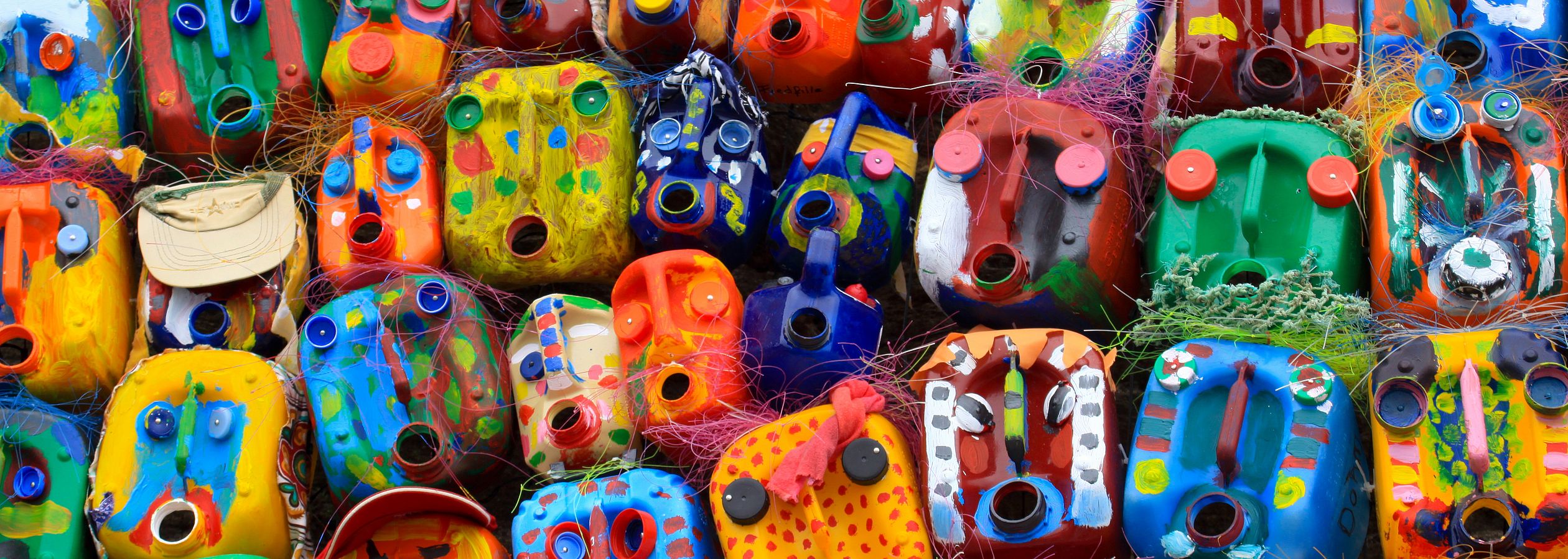 Bunt bemalte Kanister stehen wild durcheinander