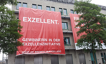 Universitätsgebäude mit rotem Banner.