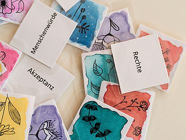 Bunte Karten und Textkarten liegen auf einem Tisch.
