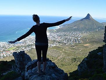 Frau steht auf Berg, unter ihr Kapstadt.