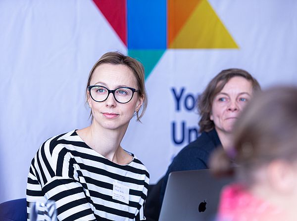 Drei Frauen im Close-up vor YUFE Logo