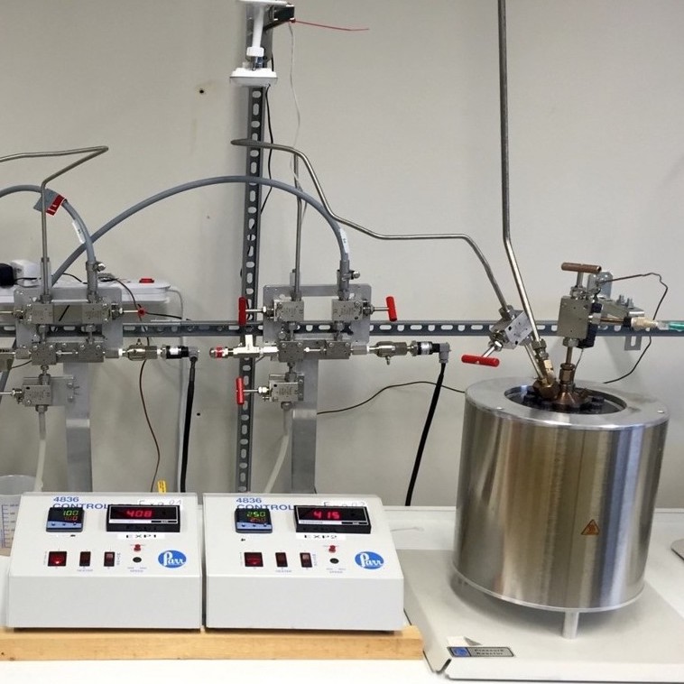 Das Bild zeigt einen Reaktor vom Typ "Dickson" neben einem Bedienelement, auf dem Druck und Temperatur abgelesen werden können